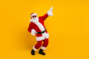 Fototapeta na wymiar Full size profile portrait of grandfather santa dance direct finger empty space new year eve sale isolated on yellow color background