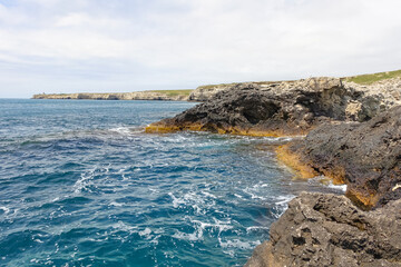 Cape Tarkhankut on the Crimean peninsula. The rocky coast of the Dzhangul Reserve in the Crimea. A sunny summer day. The Black Sea. Turquoise sea water.