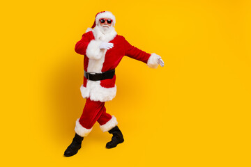 Full length portrait of excited aged santa enjoy dancing chilling empty space christmas event isolated on yellow color background