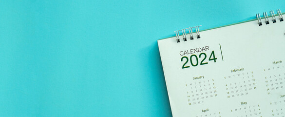 close up top view on calendar 2024 on blue background with copy space for happy new year resolution...