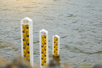 There are 3 sizes of cement poles to measure the water level in the reservoir to measure large amounts of water in the rainy season. and less water in the dry season. Soft and selective focus. - obrazy, fototapety, plakaty