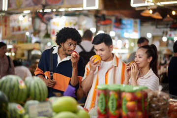 Fototapeta premium Group of young people walking in local market looking for fresh organic fruits and vegetables