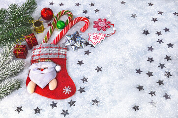 Christmas snowy background with Christmas sock, lollipops, Christmas tree toys, branches, cones. Merry Christmas concept.