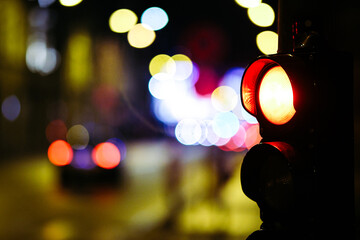 Pedestrian traffic light in the street junction in the city with beautiful bokeh lights in the night. Defocused
