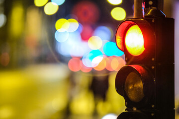 Pedestrian traffic light in the street junction in the city with beautiful bokeh lights in the night. Defocused - obrazy, fototapety, plakaty
