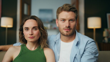 Portrait relaxed family sitting sofa at room. Calm couple watching television
