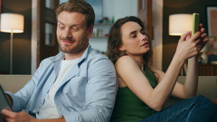 Love couple using gadgets cozy house zoom on. Woman showing mobile phone to man