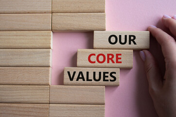 Our core values symbol. Concept words Our core values on wooden blocks. Beautiful pink background....
