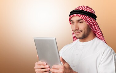 A Saudi man holding a tablet computer