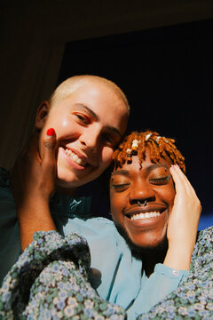 Portrait of two multiracial friends smiling into the camera