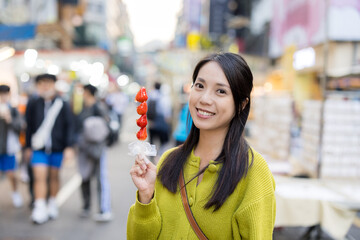 Woman hold with Tanghulu traditional Chinese hard caramel coated strawberry skewer