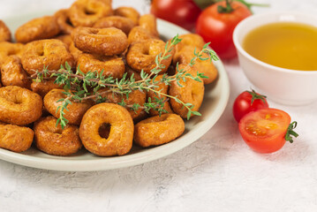 Vegetable italian pastry taralli or tarallini with  ingredients tomatoes,  thyme in plate and olive oil in bowl