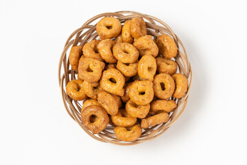 Traditional italian snacks taralli or tarallini in a wicker plate isolated on white background top view