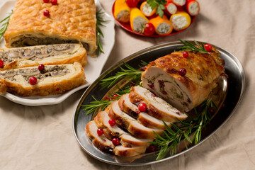 Traditional festive Christmas dishes on the table. Wellington with mushrooms, stuffed turkey roll