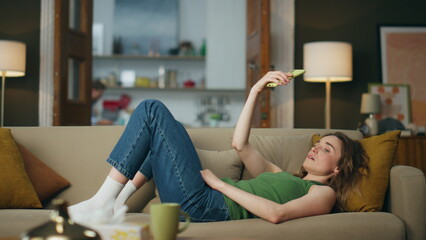 Suffering lady crying alone laying sofa indoors. Sad woman holding mobile phone