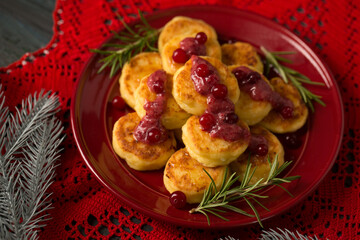 Delicious Cheese pancakes decorated with rosemary and cranberries, a homemade Christmas dessert