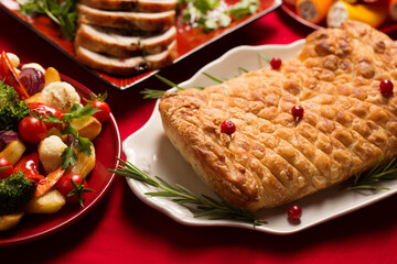 Traditional festive Christmas dishes on the table. Wellington with mushrooms, stuffed turkey roll