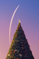 Christmas tree and jet plane in the sky. 