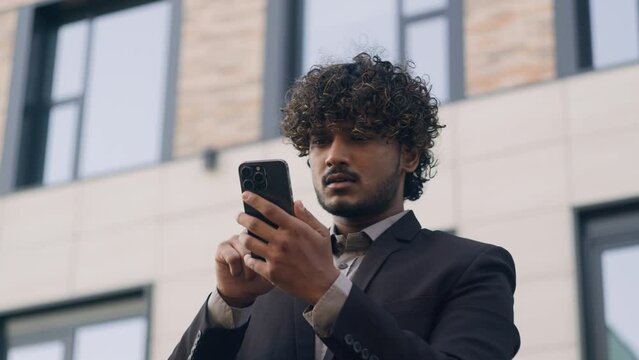 Arabian businessman Indian business entrepreneur man manager leader employer looking for location using geolocation GPS maps application mobile phone find way road lost outdoors smartphone navigation