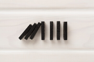 Black domino tiles on wooden background, top view
