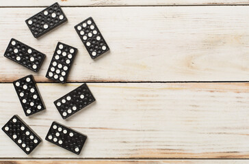 Black domino tiles on wooden background, top view