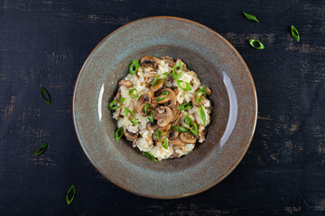 Italian cuisine - risotto with mushrooms. Cooked arborio rice with parmesan cheese and mushrooms