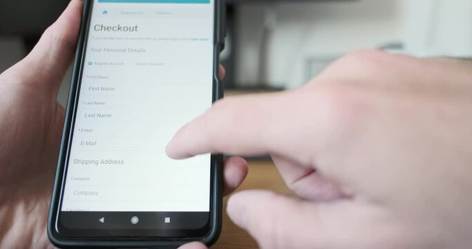 Man's finger presses checkout button on smartphone screen. Front view, close-up. Concept of online payment, purchase, shopping.