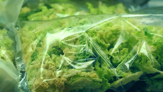 green salad. grocery supermarket. packaged fresh greens. Close-up. fresh, washed lettuce leaves in transparent packaging, ready to eat, on a shelf in grocery section of a supermarket. grocery store.