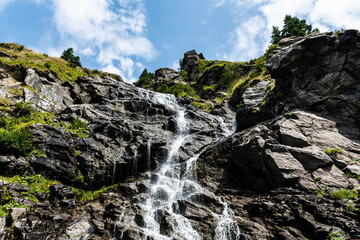 Fototapeta na wymiar Capra waterfall also known as Iezerului waterfall, located on the southern slope of the Făgăras Mountains, right next to Transfagarasan, between Cabra Capra and Balea Lake, on DN7C. Romania.