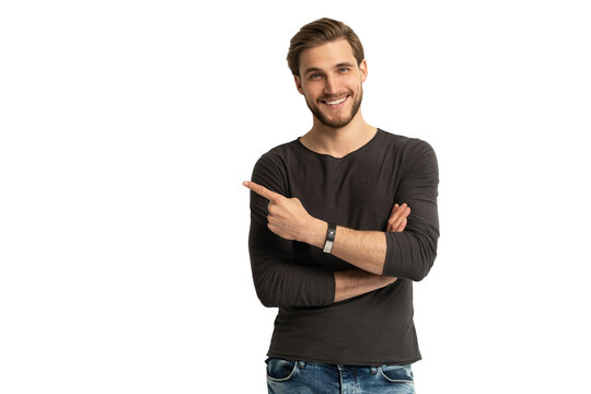 Positive young man pointing aside with fingers hand gesture at copy space advertising product, presenting sale discount standing isolated on transparent