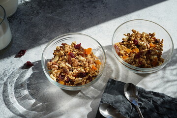 granola with dried fruits, nuts in a transparent bowl, hard light, no people, cozy atmosphere