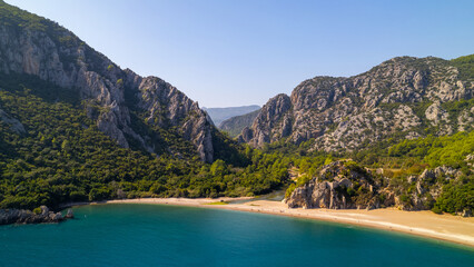 Obraz premium Captured the breathtaking beauty of Olimpos, Cirali Beach in Antalya, Turkey on a spectacular summer day in 2023, using a drone to explore the coastline and the majestic mountains in the background. 