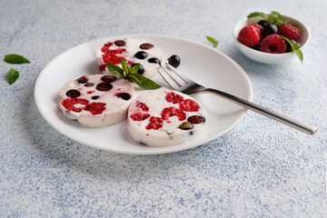 creamy dessert with berries, raspberries and currants on a white plate, close-up, no people, minimalism