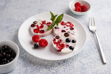creamy dessert with berries, raspberries and currants on a white plate, close-up, no people, minimalism