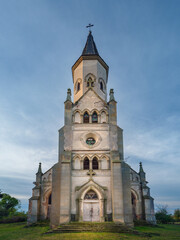 Fototapeta premium central view to facade of catholic abandoned cathedral in morning twilight