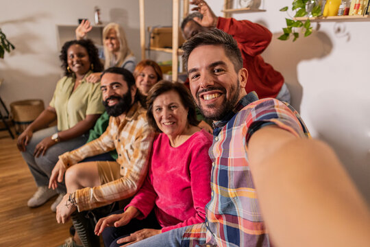 group family friends multigeneration multiracial make selfie with smart phone in the living room at home on the sofa