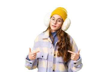 Teenager girl wearing winter muffs over isolated chroma key background proud and self-satisfied