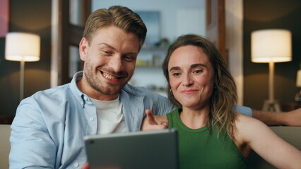 Laughing lovers watching tablet comedy at home closeup. Two people having fun