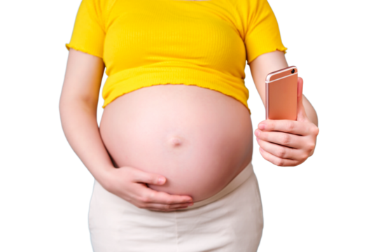 A pregnant woman looks at the phone screen, isolated on a white background