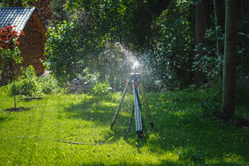 garden sprinkler on a tripod watering new lawn