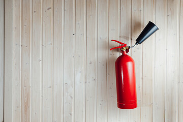 fire extinguisher on wooden deal board wall with copy-space