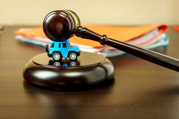 small car on the table in the courtroom. Gavel on the desk in the courtroom. Road accident, law,...