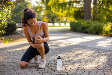 Woman runner hold her sports injured knee. Cropped Image of Woman Runner Hold Her Sports Injured...
