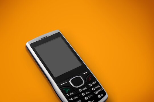 old retro mobile phone on yellow background.