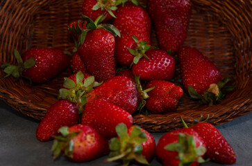 strawberries in a basket falling on gray table