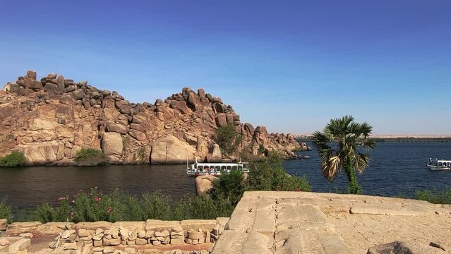 Barges sailing on the Nile. View from Temple of Philae. Rocky islet in the Nile. Egypt.