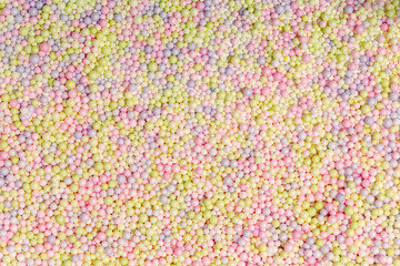 Brightly colored polystyrene beads texture as full-frame background. Colorful bright background, multi-colored balls. Sweet nice background candy