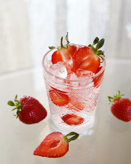 transparent glass with ice and strawberries, strawberries next to it, minimalism, no people, light frame