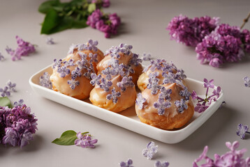 dessert eclairs  decorated with lilacs in sugar, light background, minimalism, no people