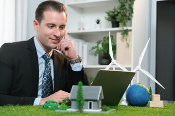 Businessman planning on his laptop for implementation of clean and sustainable energy to reduce CO2...